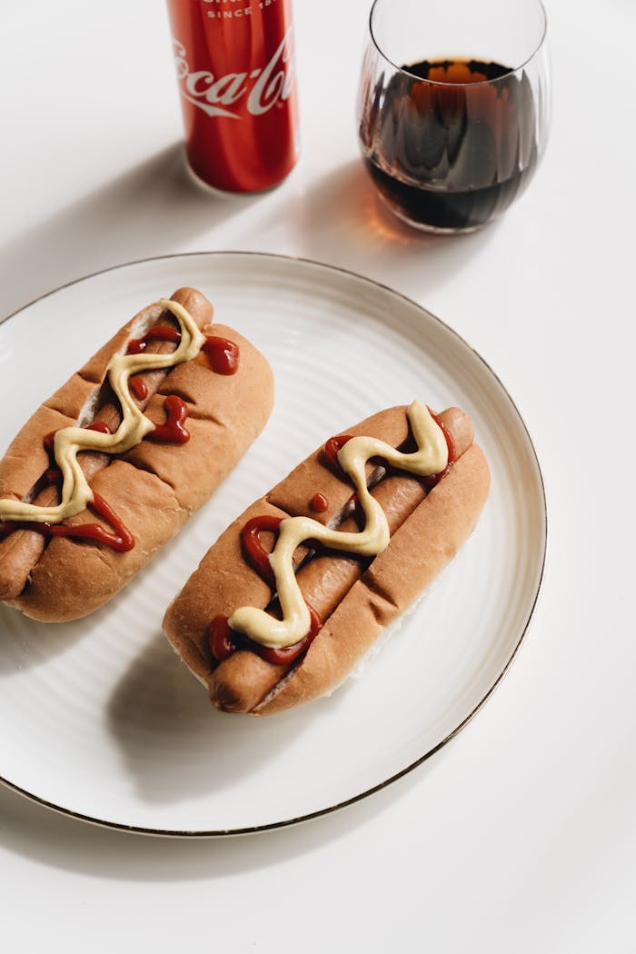 Mastering the First Impression: Your intriguing post title goes here Tasty hot dogs with mustard and ketchup, served with Coca-Cola, perfect for fast food lovers.