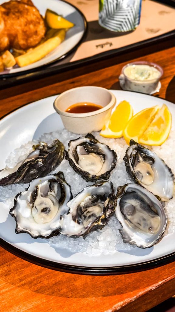 Plate of fresh oysters on ice with lemon wedges, perfect for seafood lovers in Fremantle.