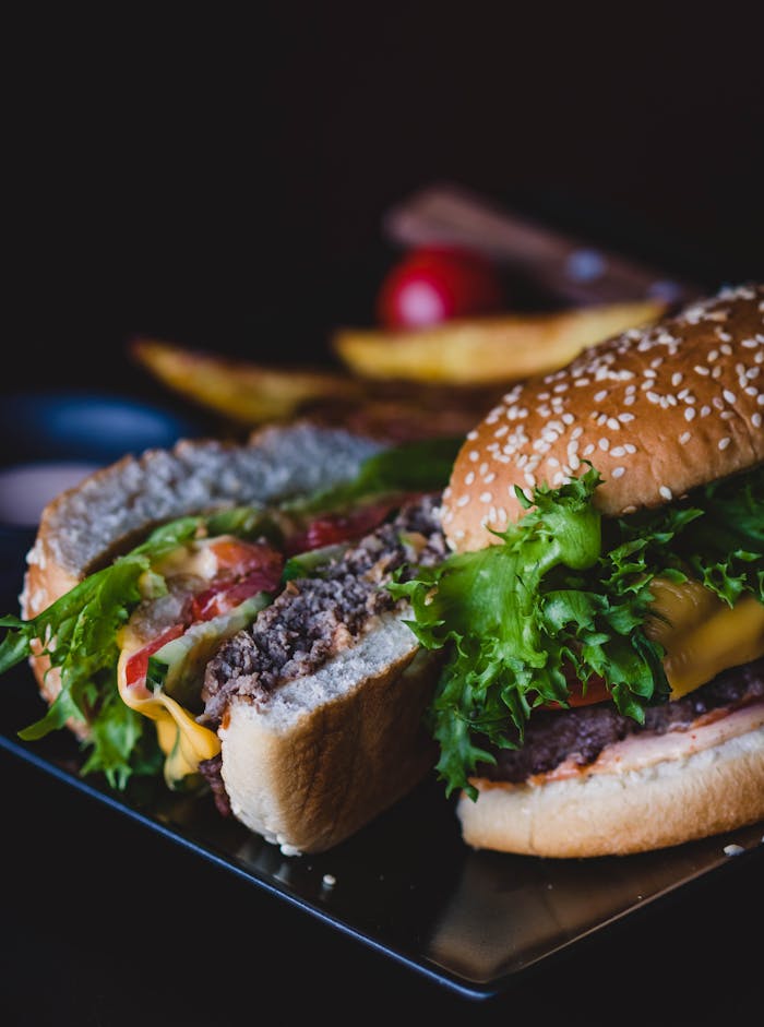 Delicious cheeseburger with fresh lettuce and tomatoes served on a dark plate.